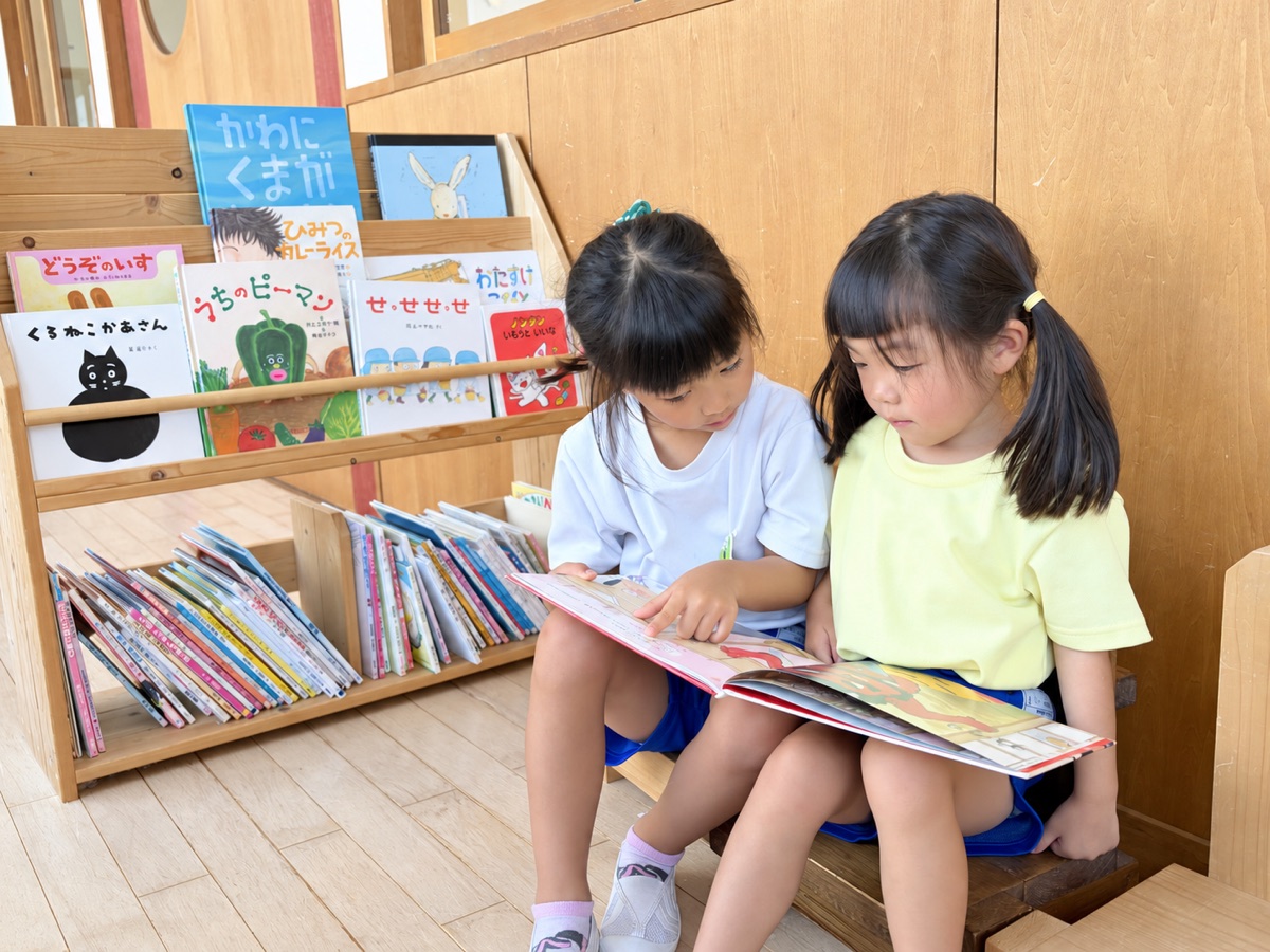 一緒に絵本を読む子ども達