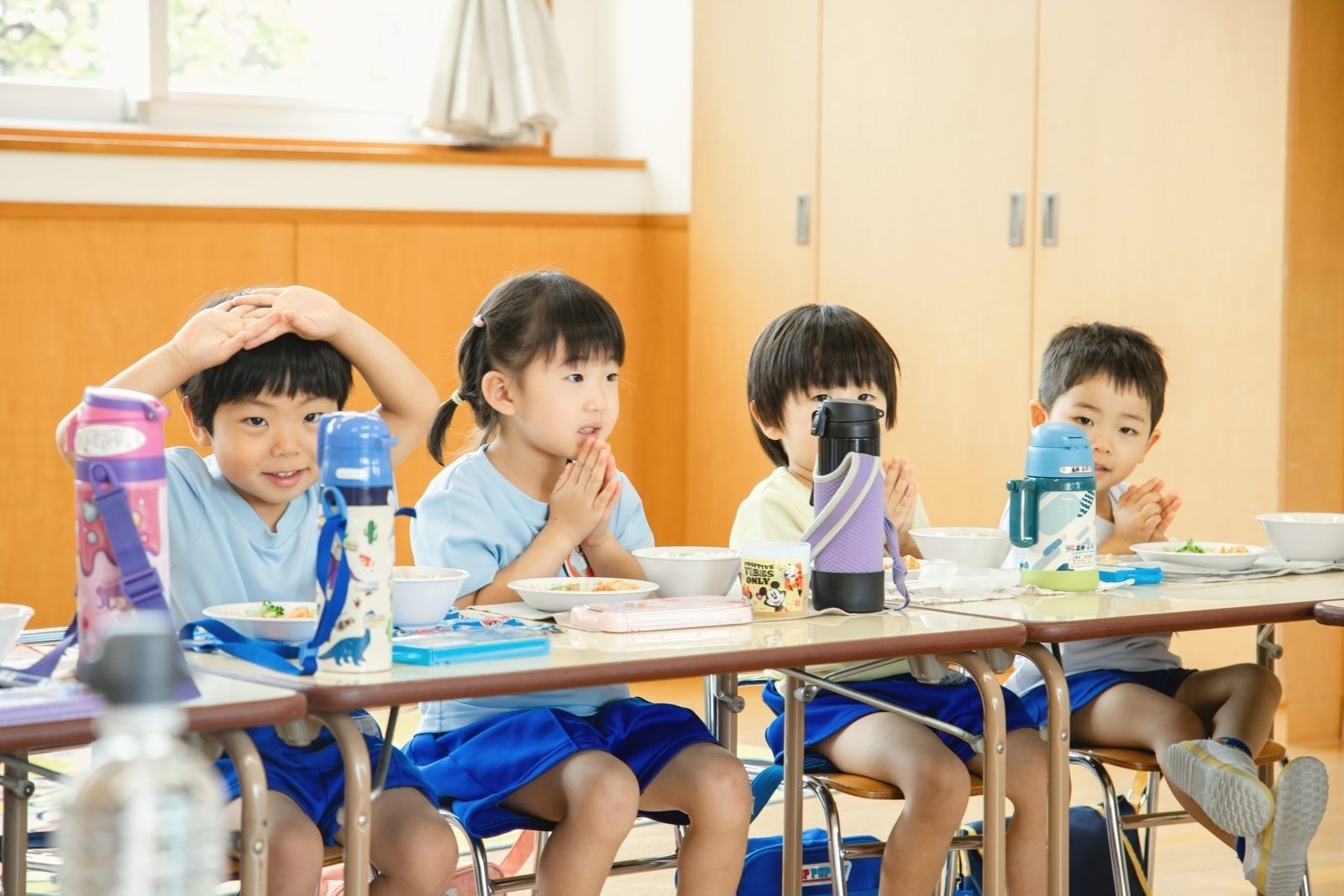給食の前にみんなでいただきますをする子ども達