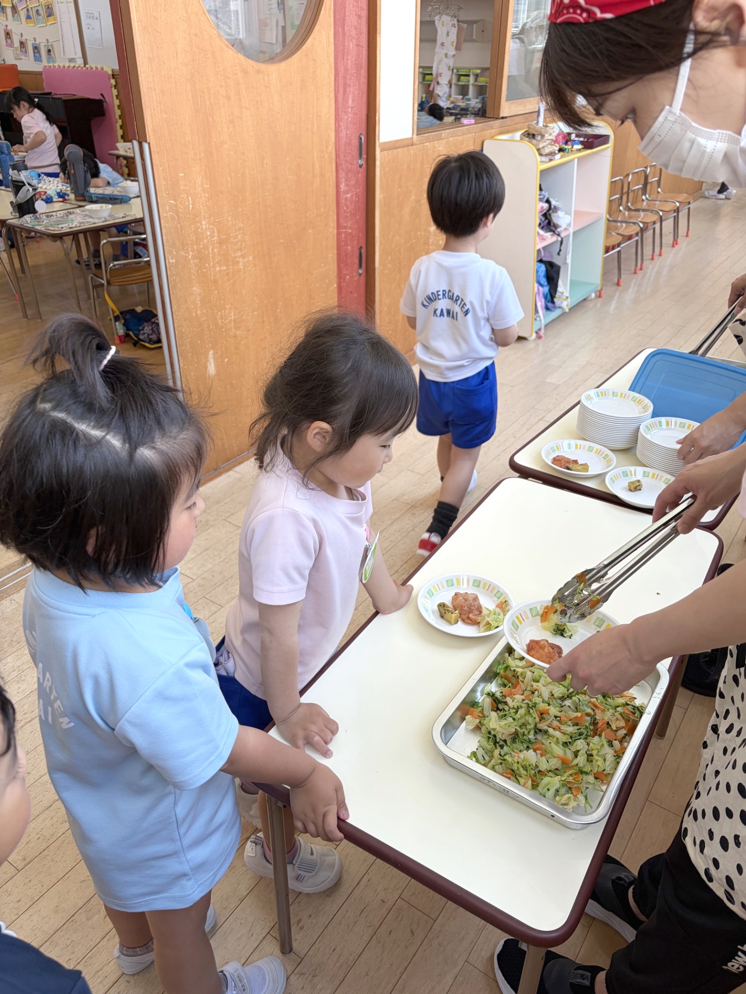 自分で選んだおかずを受け取る園児たち