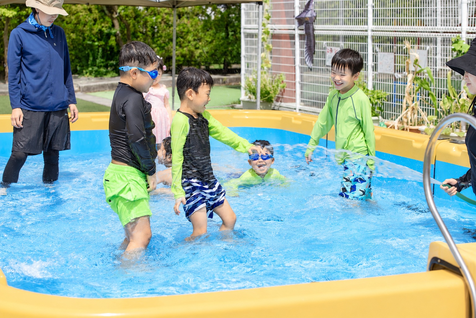 園庭のプールで水遊びを楽しむ子ども達